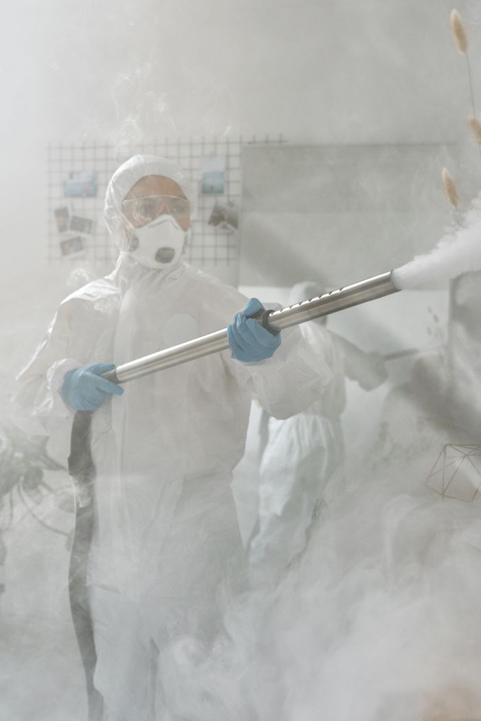 services-bg A person in full protective gear fumigating a room to ensure sterilization against viruses.